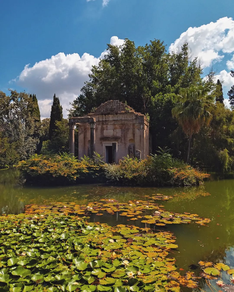 Klein klassiek tempeltje in de Giardino Inglese van de Reggia di Caserta, omringd door waterlelies op een vijver